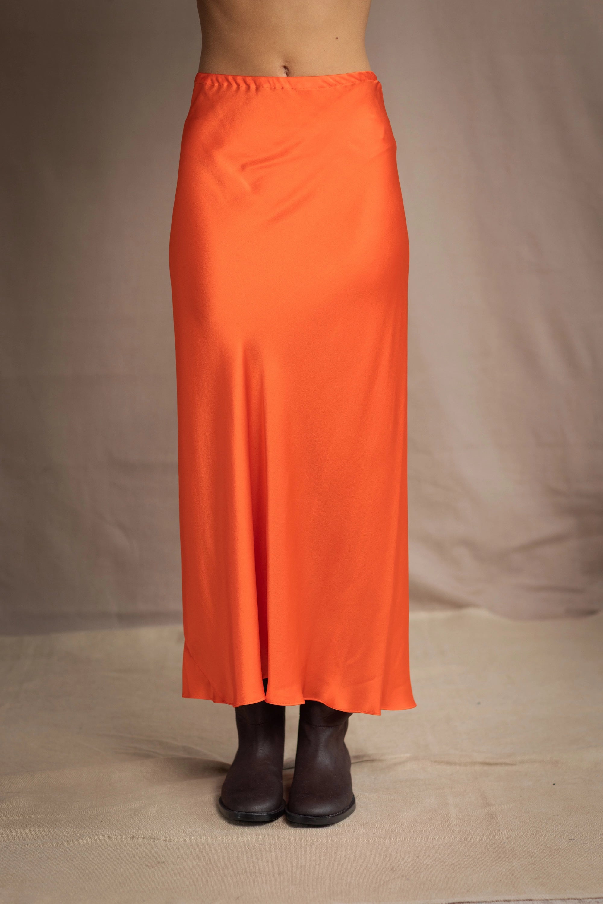 a woman wears a silk skirt in orange