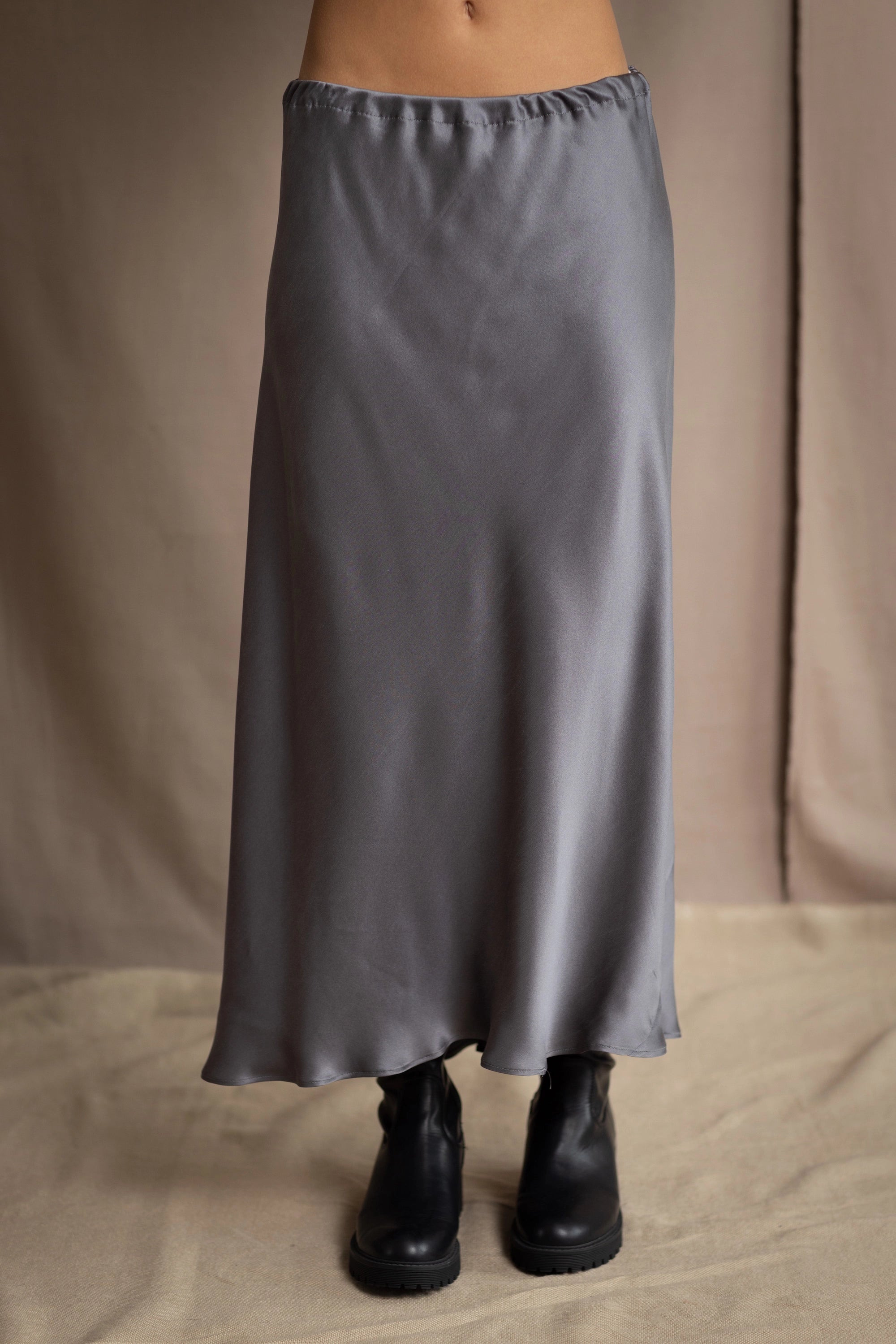 woman wearing a long gray pewter silk midi skirt with black boots