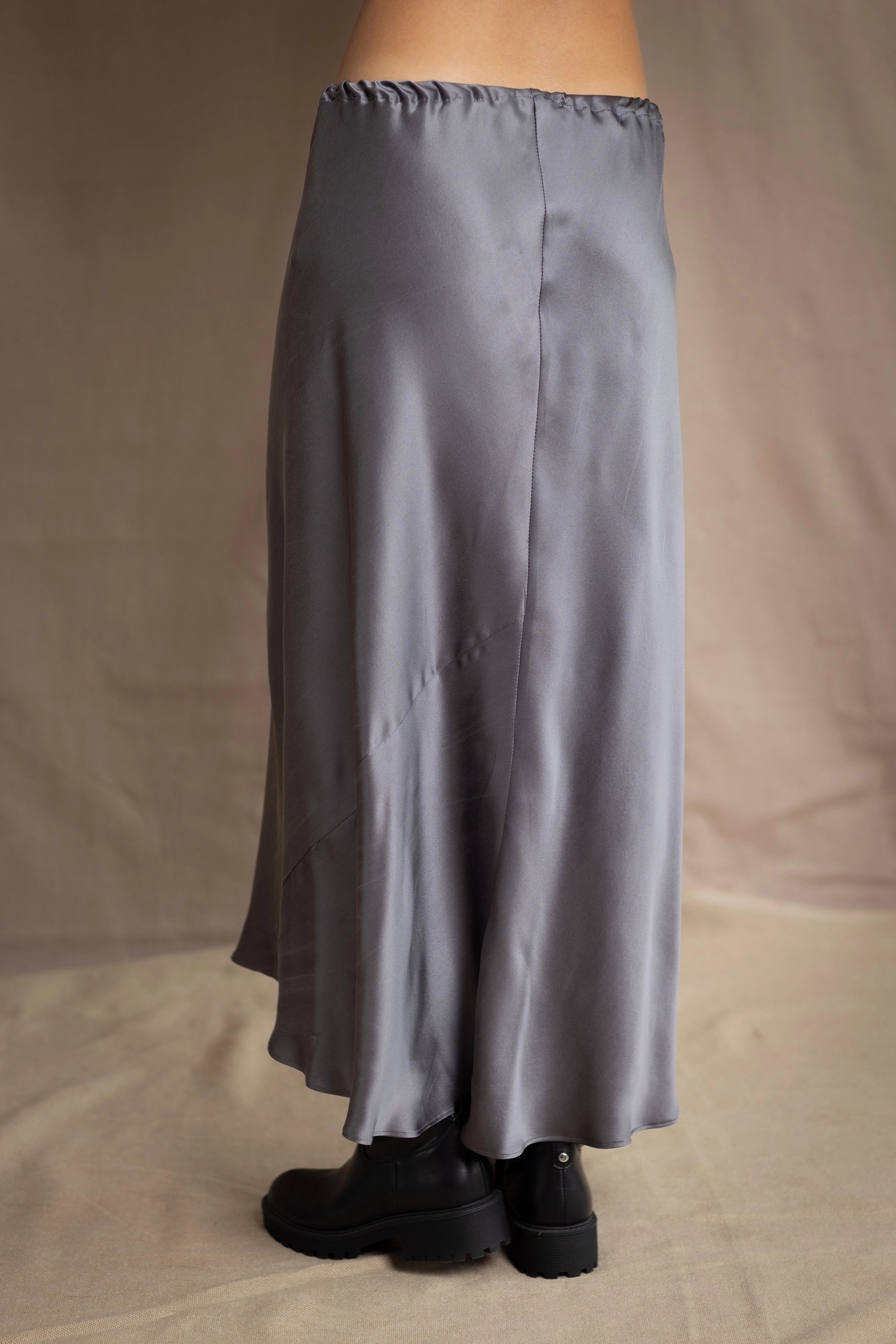 woman wearing a long gray pewter silk midi skirt with black boots