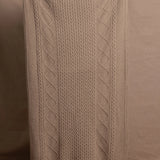 A lady wears a pure cashmere aran blanket in taupe