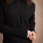 Woman wears traditional Irish Aran Sweater in Black