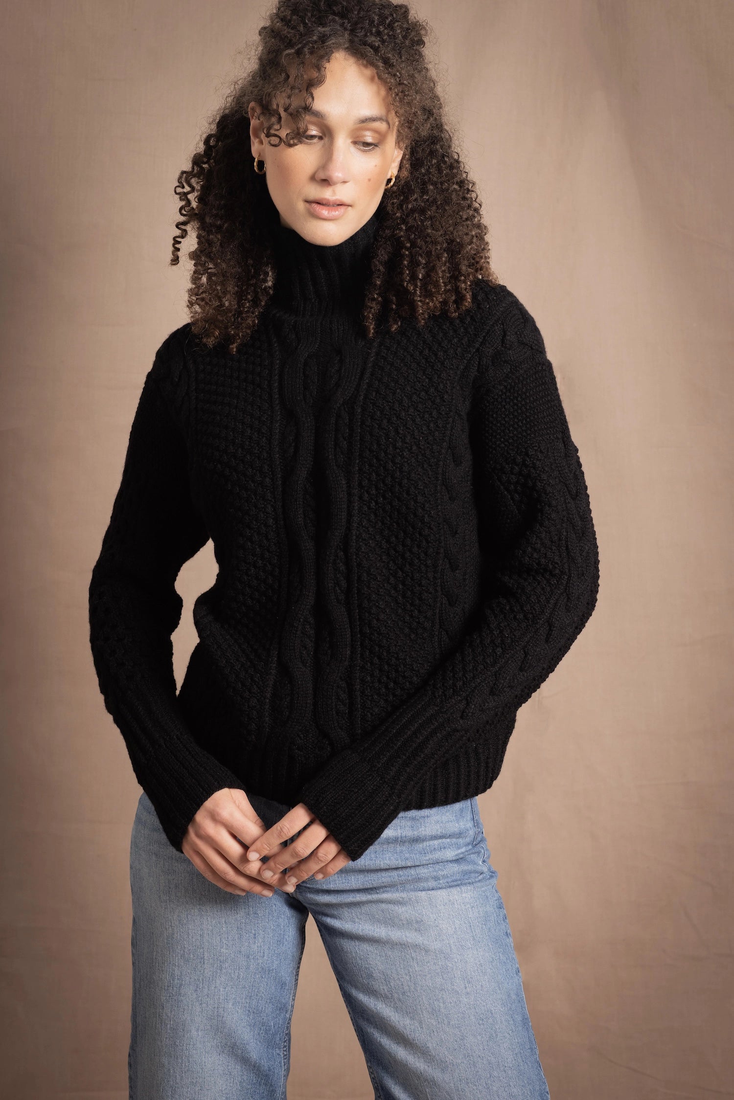 Woman wears traditional Irish Cashmere Aran Sweater in Black