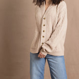 a woman wears a beige coloured cashmere aran cardigan sweater with horn buttons