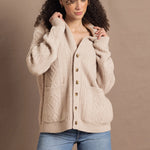a woman wears a beige coloured cashmere aran cardigan sweater with horn buttons