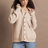a woman wears a beige coloured cashmere aran cardigan sweater with horn buttons