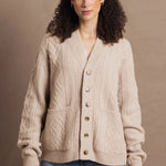 a woman wears a beige coloured cashmere aran cardigan sweater with horn buttons