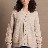 a woman wears a beige coloured cashmere aran cardigan sweater with horn buttons