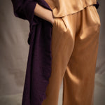 Woman wearing a dark purple cashmere lace wrap over bronze silk clothing