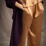 Woman wearing a dark purple cashmere lace wrap over bronze silk clothing