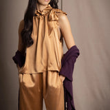 Woman wearing a dark purple cashmere lace wrap over bronze silk clothing