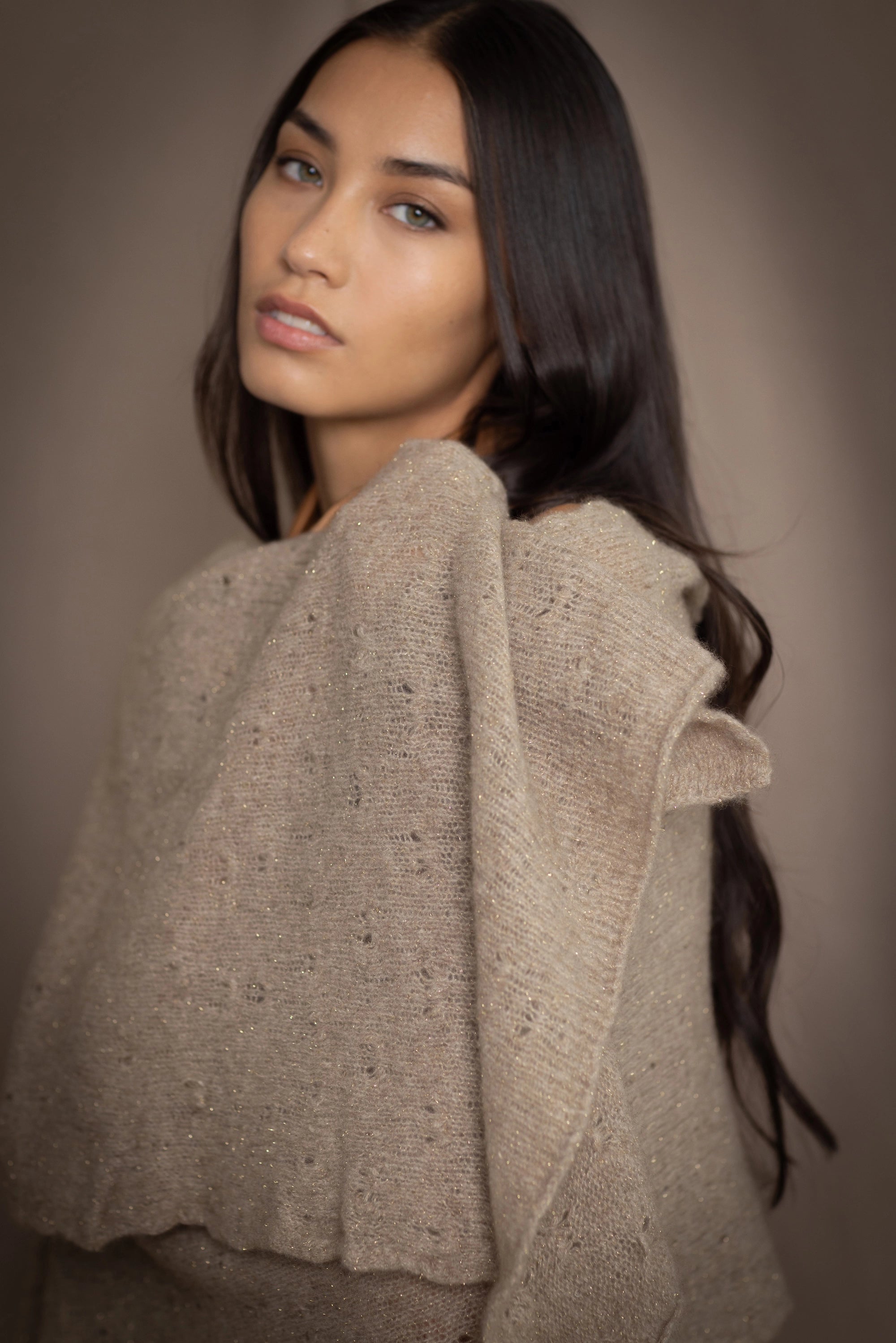 Woman wearing a beige and metallic gold cashmere lace wrap