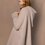 woman wearing a beige hooded oversized sweater jumper