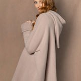 woman wearing a beige hooded oversized sweater jumper