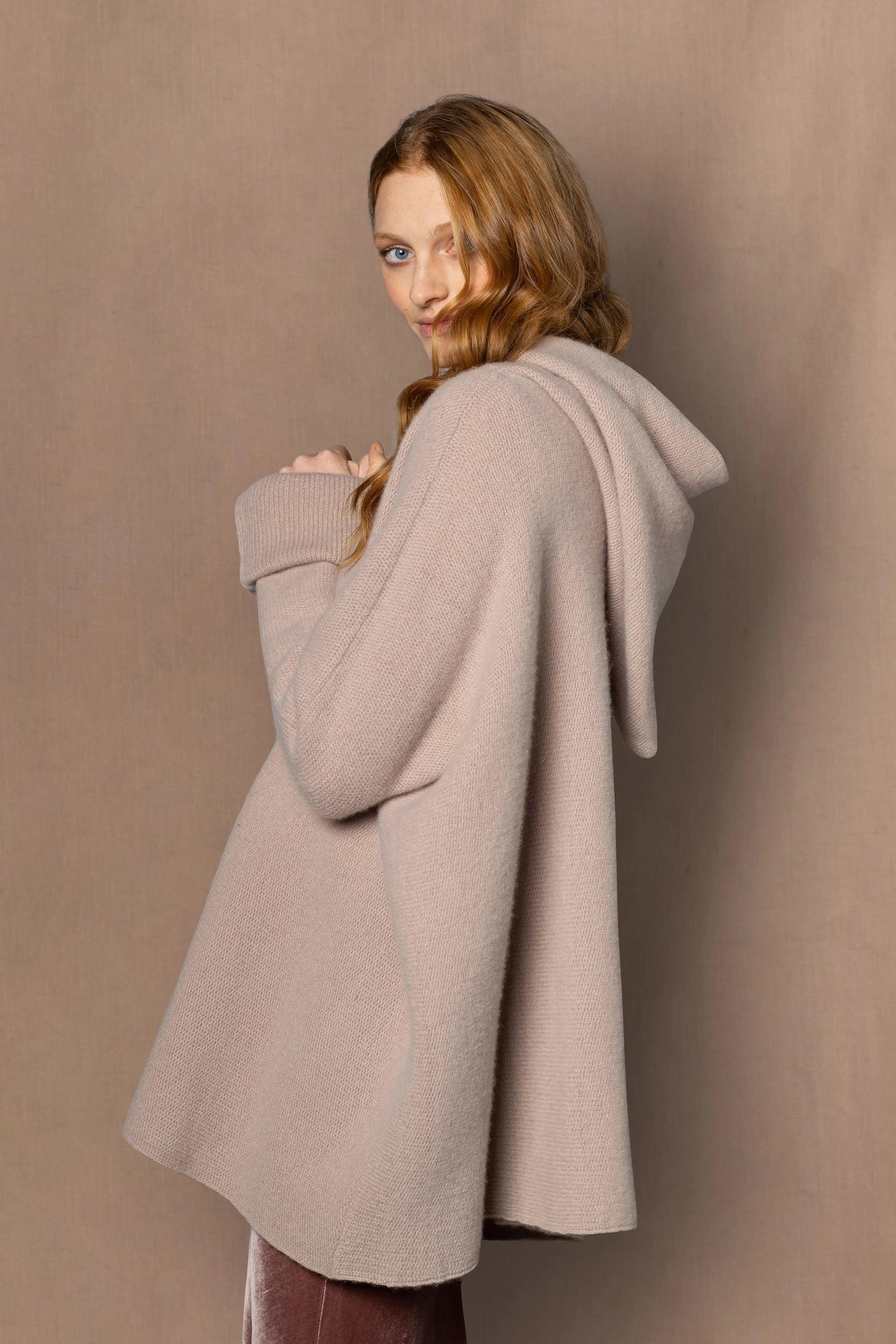woman wearing a beige hooded oversized sweater jumper