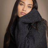 woman wearing an oversized cashmere sweater with cowl neck in black with silver metallic lurex thread