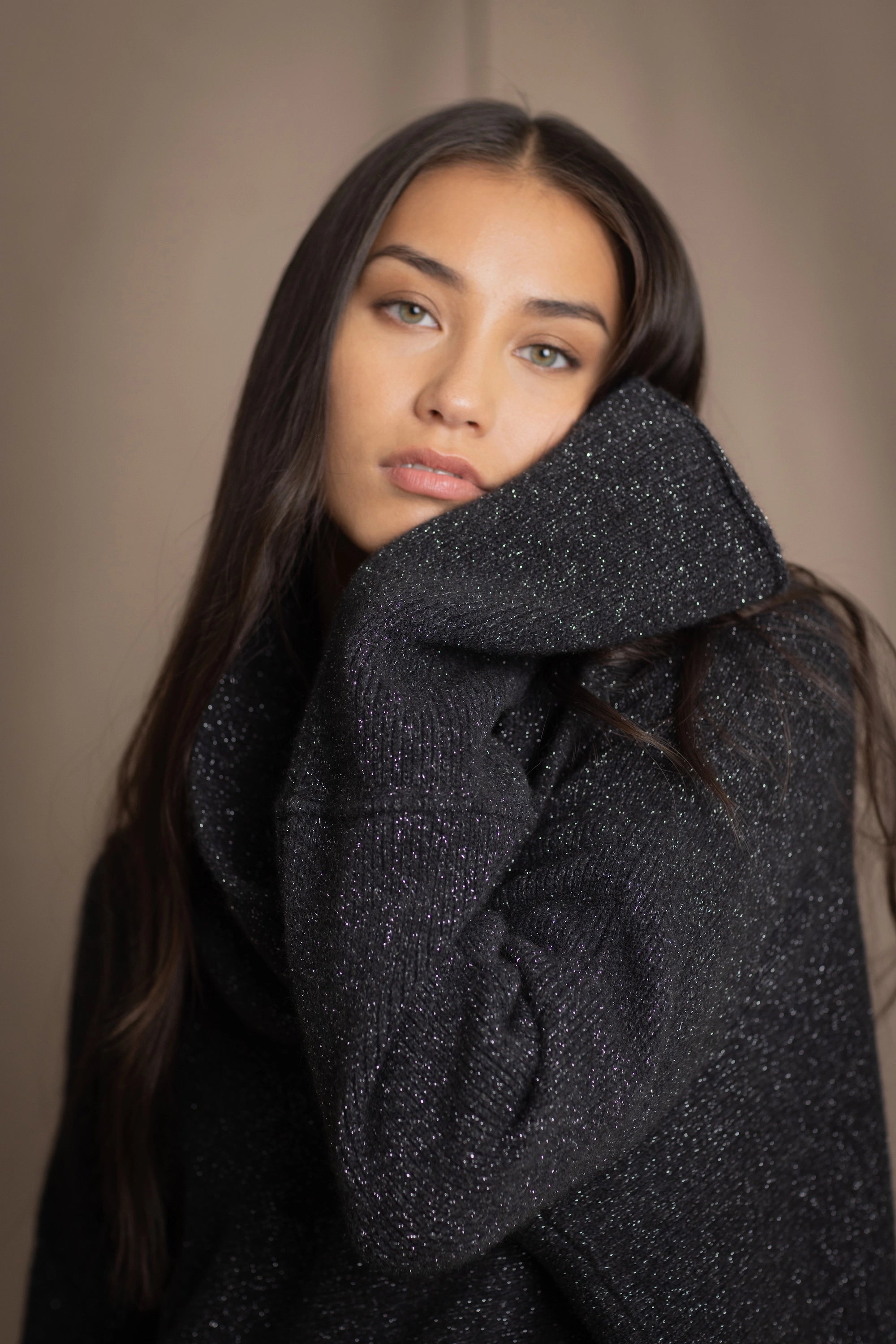 woman wearing an oversized cashmere sweater with cowl neck in black with silver metallic lurex thread