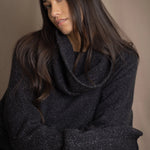 woman wearing an oversized cashmere sweater with cowl neck in black with silver metallic lurex thread