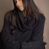woman wearing an oversized cashmere sweater with cowl neck in black with silver metallic lurex thread