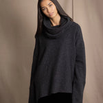 woman wearing an oversized cashmere sweater with cowl neck in black with silver metallic lurex thread over silk velvet skirt in black