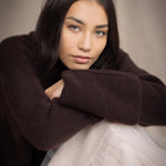 woman wearing an oversized cashmere sweater with cowl neck in dark brown over  pale pink tulle skirt