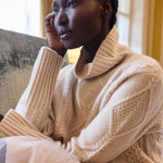 woman wearing a cashmere aran cable knit jumper or sweater in pale pink