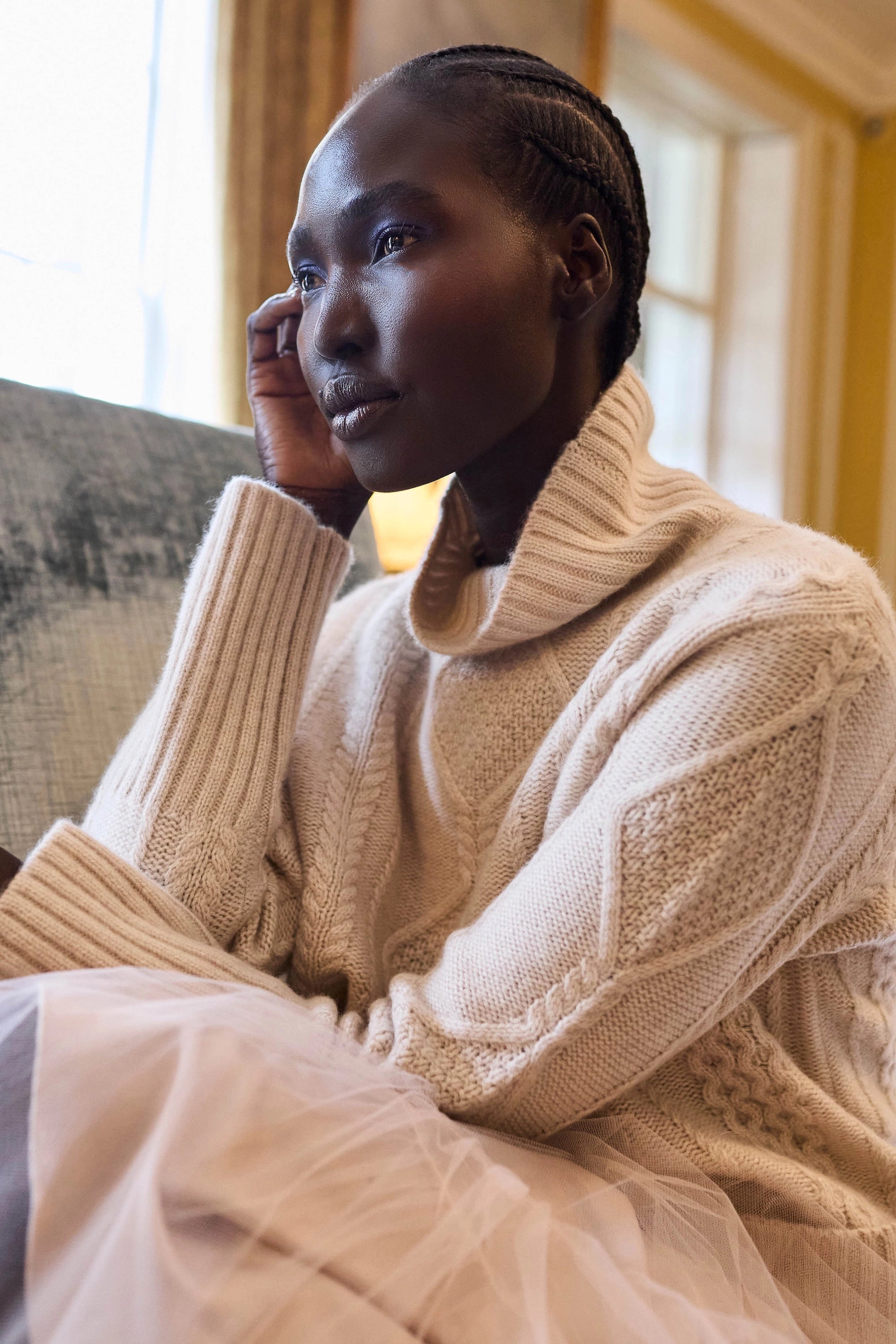 woman wearing a cashmere aran cable knit jumper or sweater in pale pink