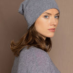 a woman wearing a cashmere beanie hat in grey
