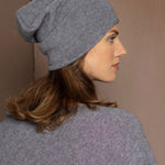 a woman wearing a cashmere beanie hat in grey