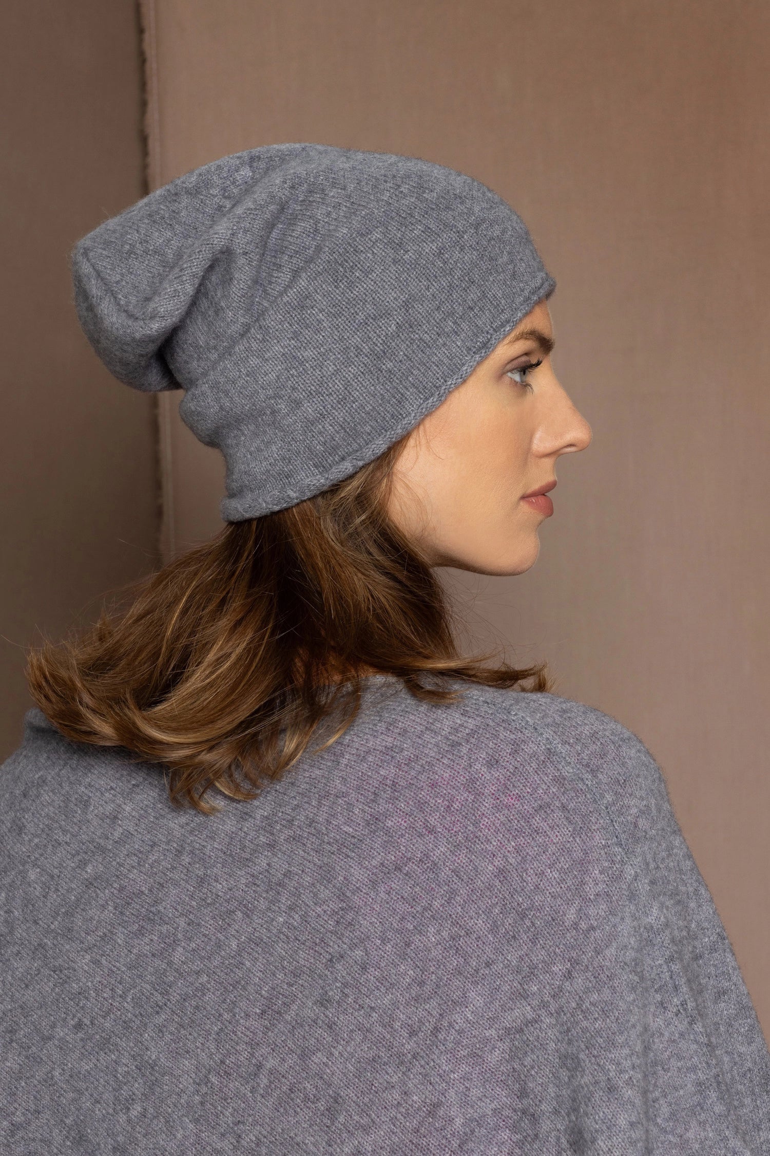 a woman wearing a cashmere beanie hat in grey