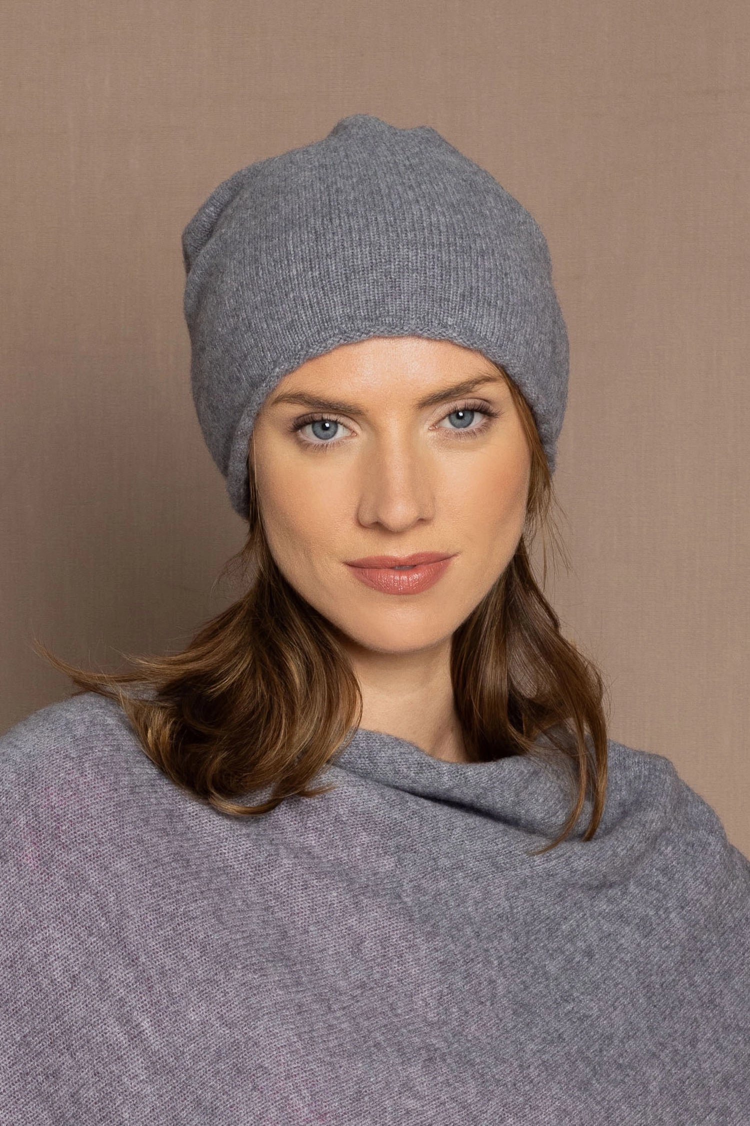 a woman wearing a cashmere beanie hat in grey