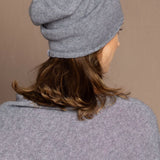 a woman wearing a cashmere beanie hat in grey