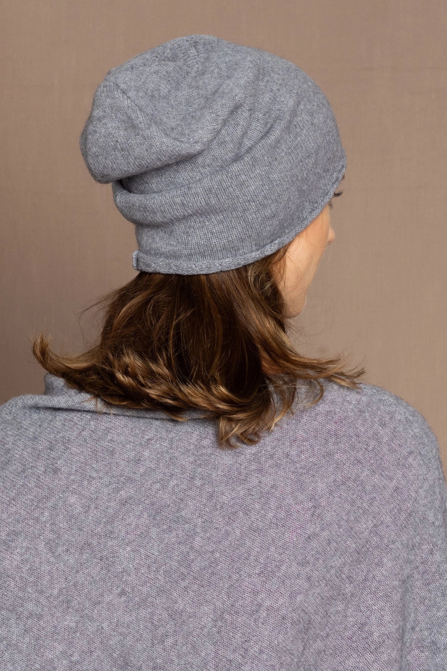 a woman wearing a cashmere beanie hat in grey