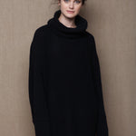 A woman wears an oversized 100% cashmere sweater in black