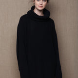 A woman wears an oversized 100% cashmere sweater in black