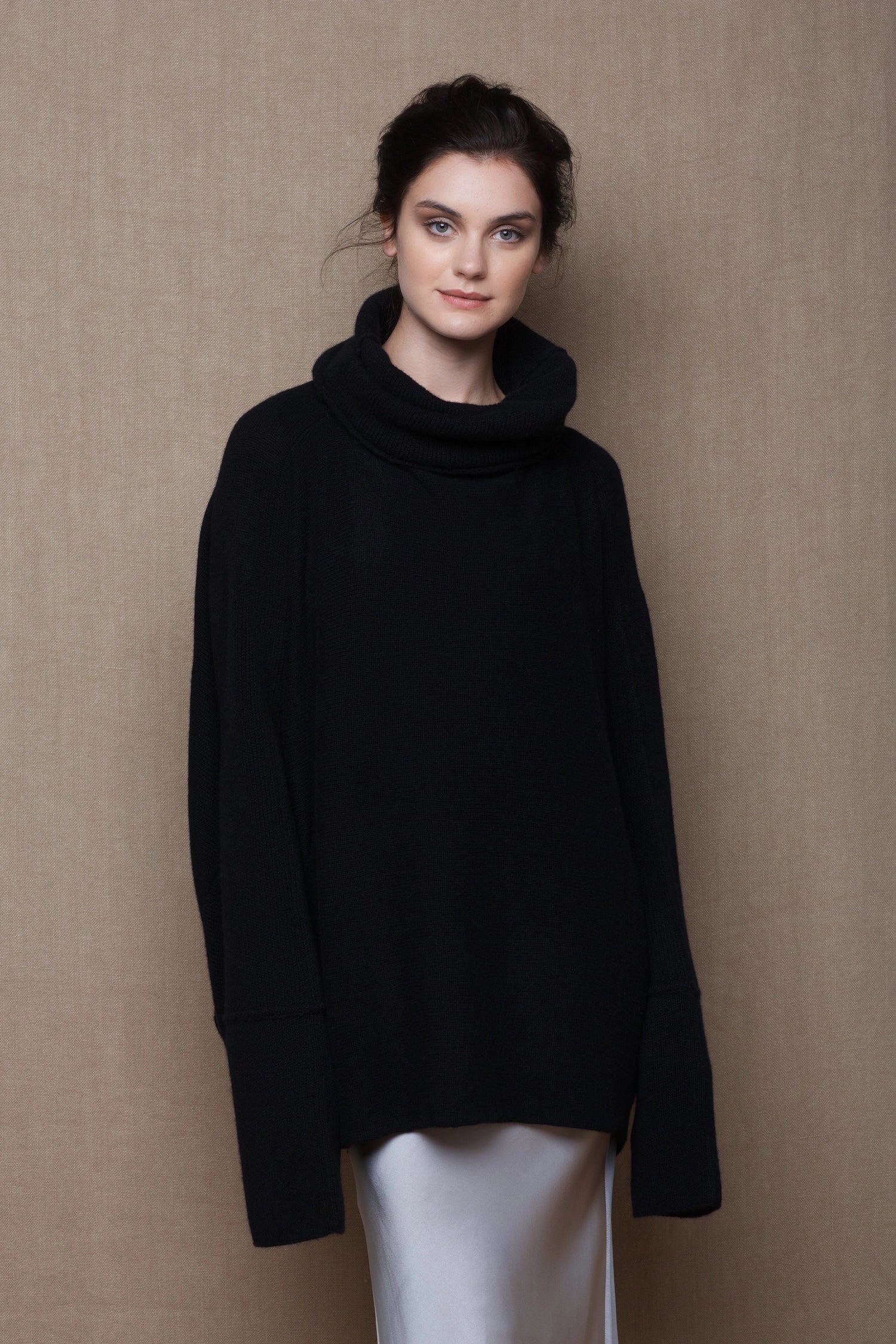 A woman wears an oversized 100% cashmere sweater in black