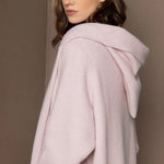 woman wearing a long cashmere hooded coat cardigan in pale pink