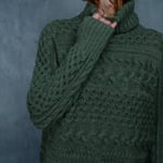A video of a woman wearing a 100% cashmere aran sweater in fern green