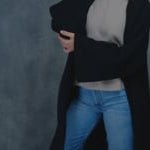 a woman wears luxury cashmere tee sweater in beige with black cashmere coat on top