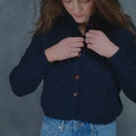 a woman wears a traditional Irish aran cardigan button down sweater made from pure 100% cashmere in navy