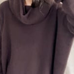 video of a woman wearing an oversized cashmere sweater with cowl neck in dark brown over  pale pink tulle skirt