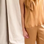 video of a woman wearing a bronze pussy bow silk blouse with matching silk trousers