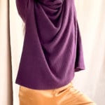 video of a woman wearing a cashmere fisherman turtleneck sweater in dark purple with bronze silk trousers