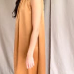 video of a woman wearing a bronze silk sleeveless dress