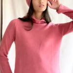 video of a woman wearing a cashmere turtleneck sweater in dusty rose pink and matching cashmere beanie hat in dusty rose pink