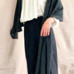 video of woman wearing a white silk blouse with ruffled details and a sparkly black cashmere wrap