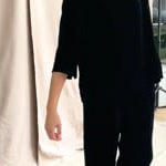 video of a woman wearing a 3/4 sleeve silk velvet top in black with matching silk velvet trousers