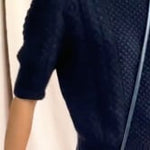 video of a woman wearing a vegan leather pouch crossbody bag in navy metallic