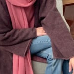 video of a woman wearing a long brown cashmere coat, pink cashmere sweater, pink cashmere wrap scarf and jeans.