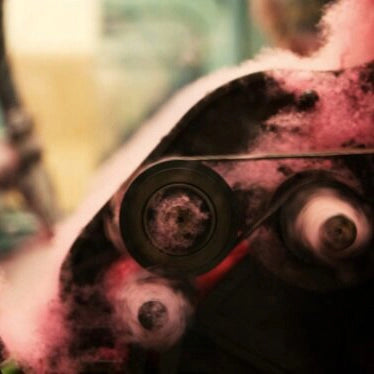 a photo of fluffy cashmere yarn being processing in a pink colour