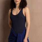 A woman wears a bright blue cashmere shawl wrapped around her